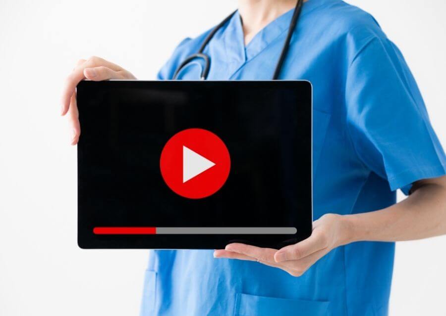 Arzt hält Tablet mit YouTube Player