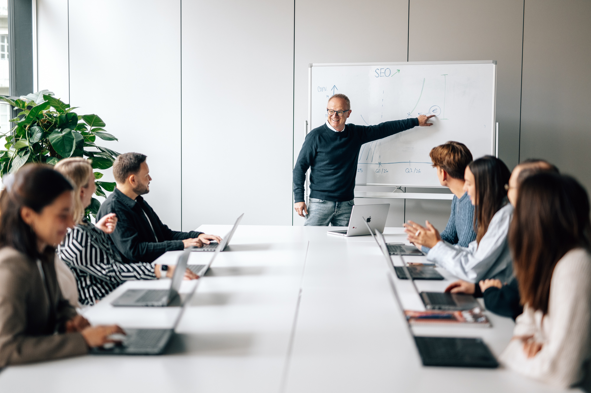 Markus zeigt dem Team etwas an der Tafel.